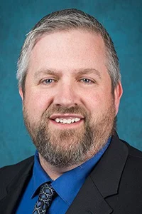 A headshot of Gregory McManus